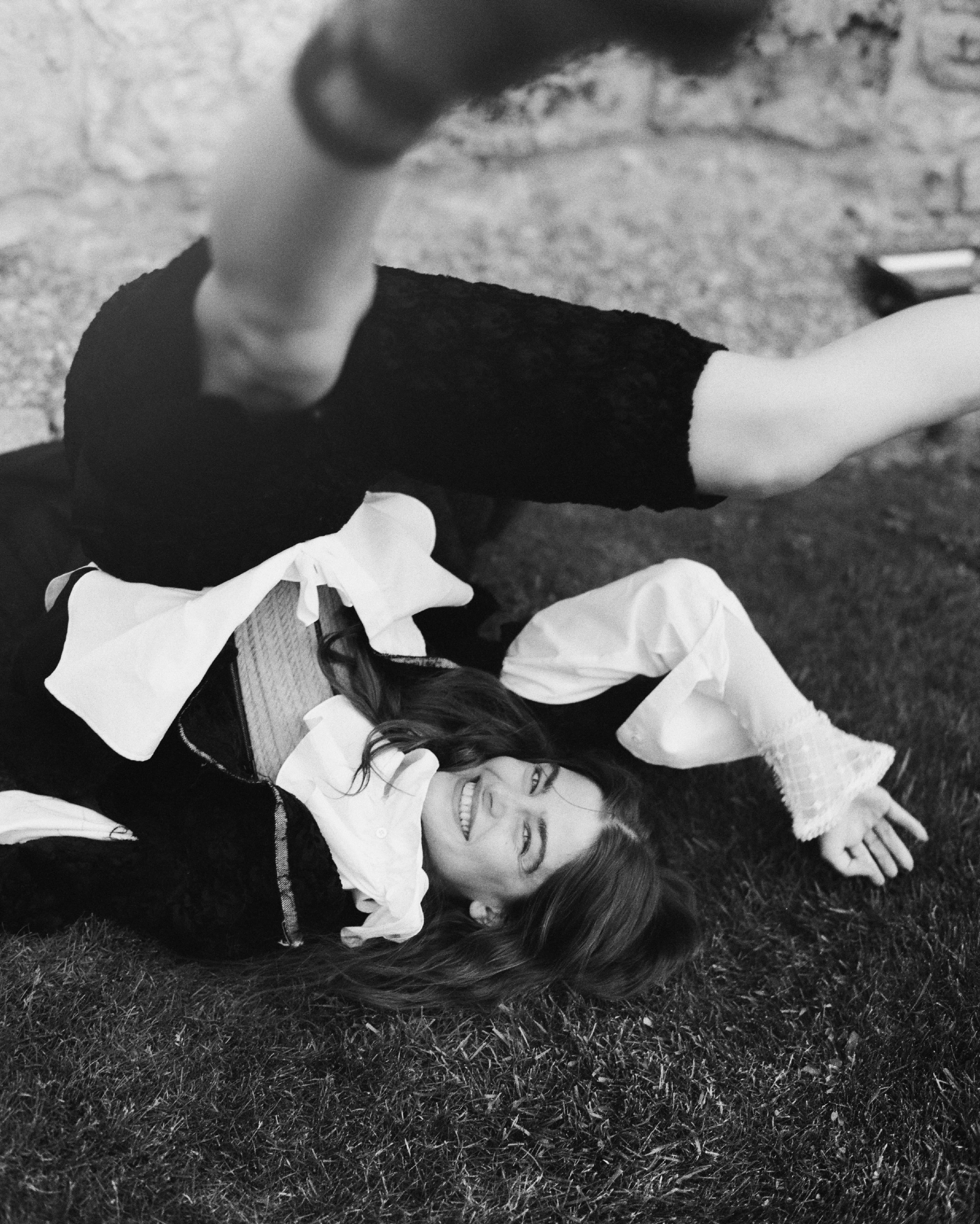 Woman playfully rolling over grass